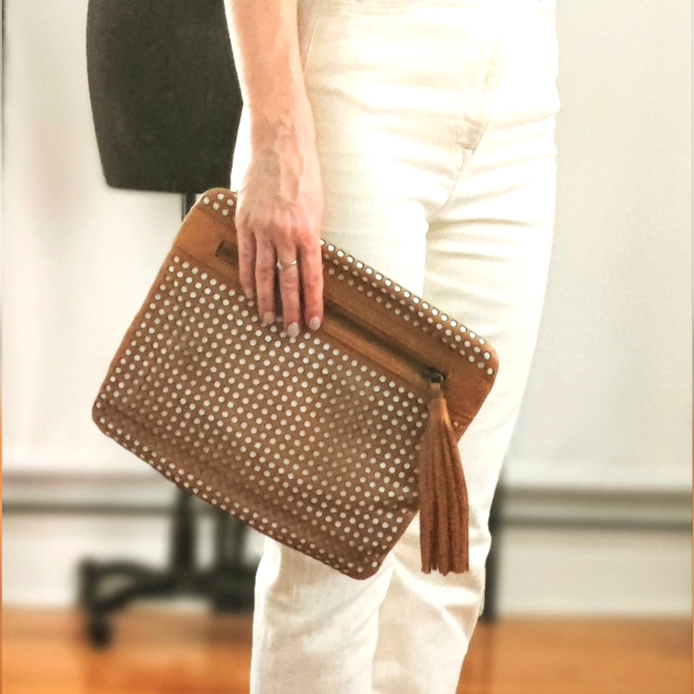Cynthia Vincent brown perforated vegan leather clutch with a tassel
